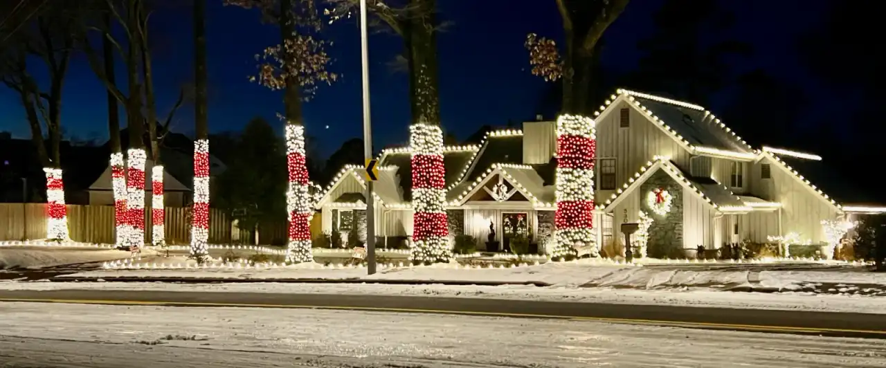 Snow-dusted home with red and white holiday decor